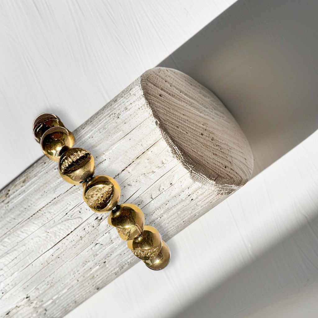 A stack of Pyrite bracelets, featuring sparkling druzy pyrite, displayed on a bracelet stand. Known as the "stone of abundance," Pyrite attracts wealth, prosperity, and success while radiating confidence and vitality. The druzy formations amplify its energy, providing a protective shield against negative influences. Stylish and versatile, these bracelets add chic sophistication to any outfit while offering grounding and empowering benefits.