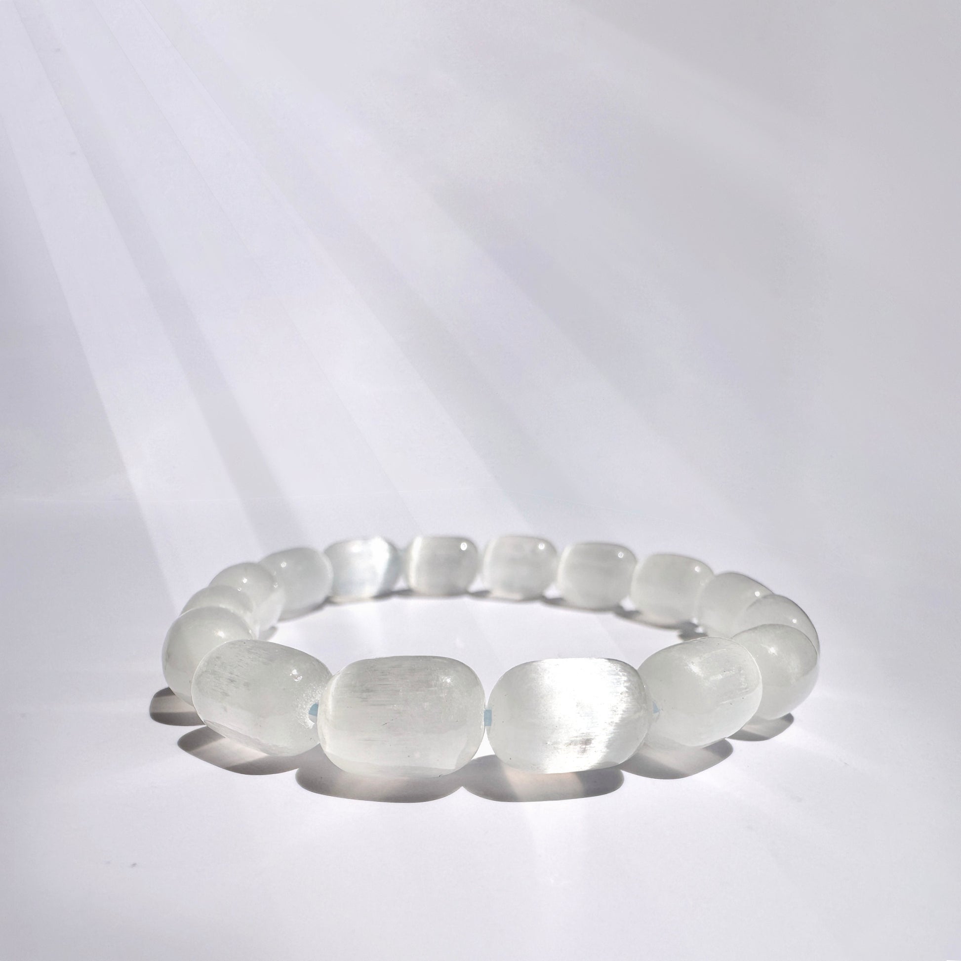 A Selenite bracelet that serves as a powerful tool for spiritual cleansing and energy alignment, helping to eliminate negative energy and enhance mental clarity. It promotes peace and strengthens the wearer's connection to the divine, making it perfect for meditation and aura balancing.