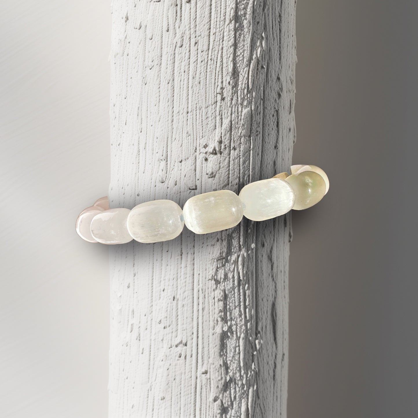  A Selenite bracelet featuring 12.5mm beads displayed on a bracelet stand, designed to fit petite to medium wrists (5.5" - 6"). This bracelet is known for its spiritual cleansing and energy alignment properties, clearing negative energy and enhancing mental clarity while promoting peace and a deeper connection to the divine. Ideal for meditation and balancing the aura.